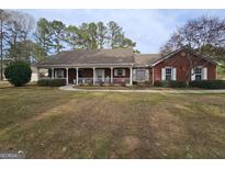 Charming brick home featuring a welcoming front porch and well-maintained landscaping in a beautiful neighborhood at 164 Turner Creek Dr, Hampton, GA 30228