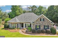 Charming single-story home features a stone facade, manicured landscaping, and a welcoming front porch at 320 Silverbell Ln, Sharpsburg, GA 30277