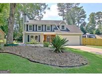 Charming two-story home featuring a well-manicured lawn, inviting curb appeal, and an attached two-car garage at 345 Summer Pl, Peachtree City, GA 30269