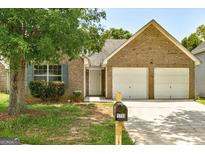 Charming brick home featuring a two-car garage and well-maintained front yard at 1735 Deer Crossing Cir, Jonesboro, GA 30236