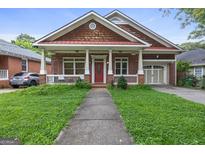 Charming brick home with a welcoming front porch and well-maintained lawn and attached garage at 1484 Mcpherson Se Ave, Atlanta, GA 30316