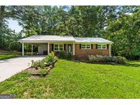 Charming brick home with a metal roof, carport, and lush green lawn at 1833 S Highway 92, Fayetteville, GA 30215