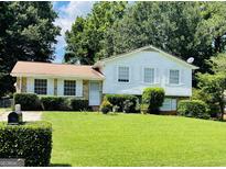 Charming home with a lush front yard, well-maintained landscaping, and classic white shutters at 8436 Magnolia Dr, Jonesboro, GA 30238