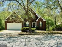 Charming brick home with a well-manicured lawn and inviting front entrance, perfect for a Gathering at 2481 Weatherstone Cir, Conyers, GA 30094