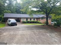 Charming single-story home with a spacious driveway and traditional brick facade at 177 Northwind Sw Ct, Lilburn, GA 30047