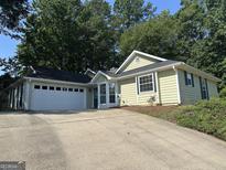 Charming single-story home with a two-car garage, complemented by mature trees and a well-maintained front yard at 539 Horseshoe Cir, Stockbridge, GA 30281