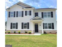Beautiful two-story home featuring a white exterior, black shutters, landscaped lawn and covered front porch at 363 Friendship Oak Way, Hampton, GA 30228