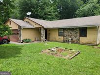 Ranch-style home with yellow siding, stone accents, and a well-maintained lawn at 259 Independence Dr, Jonesboro, GA 30238