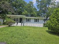 Charming single-story home with black trim, freshly cut lawn, and mature shade trees at 2934 Harris St, East Point, GA 30344