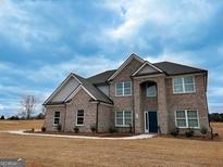 Beautiful two-story brick home with a manicured lawn and inviting entryway at 5565 Hwy 155 N, Stockbridge, GA 30281