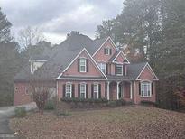 Charming two-story home with a well-maintained lawn and a welcoming front porch at 145 Mill Run, Fayetteville, GA 30214