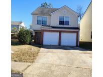 Two-story home with a brick-accented two-car garage and a well-maintained front yard at 7471 Garnet Dr, Jonesboro, GA 30236