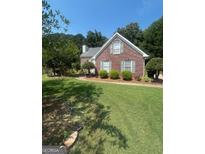 Charming single-story home with lush green lawn, mature trees, and well-maintained landscaping at 733 Stonehaven Chase, Mcdonough, GA 30253