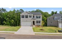 Charming two-story home features a two-car garage, manicured lawn, and a classic brick facade at 1939 Van Allen Ct, Dacula, GA 30019