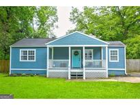 Charming blue cottage-style home with a welcoming front porch and lush green lawn at 1821 Clearwater, Marietta, GA 30067
