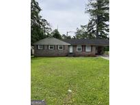 Charming single-story brick home featuring a covered carport and a well-maintained front lawn at 3929 Rockey Valley Dr, Conley, GA 30288