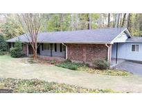 Ranch style home with mature trees, brick facade, and a well-maintained lawn at 276 Colewood Nw Way, Atlanta, GA 30328