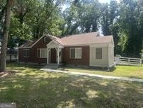 Charming single-story brick home with a well-manicured lawn and inviting front porch at 718 N Hairston Rd, Stone Mountain, GA 30083