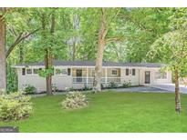 Charming ranch home with a covered front porch surrounded by a lush green lawn and mature trees at 4329 Parkview Dr, Lithia Springs, GA 30122