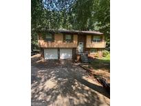 Inviting exterior of a split level home featuring an attached two car garage and mature trees at 2101 Newgate, Decatur, GA 30035