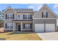 Charming two-story home with a well-maintained lawn, featuring a gray facade and attached two-car garage at 469 Ralph Still, Dacula, GA 30019