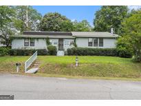 Inviting single-story home featuring a well-maintained lawn and charming curb appeal at 4705 Ernest Dr, Forest Park, GA 30297
