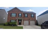 Charming two-story brick home with a well-manicured lawn and an attached two-car garage at 3484 Enterkin Ln, South Fulton, GA 30349
