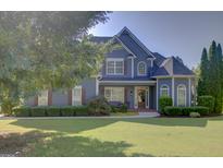 Beautiful two-story home with blue siding, lush lawn, and manicured landscaping creating charming curb appeal at 9 Warrior Way, Sharpsburg, GA 30277