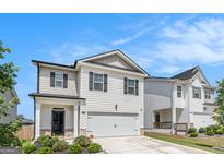 Charming two-story home with an attached garage, landscaped yard, and neutral exterior at 12167 Conrad Cir, Hampton, GA 30228
