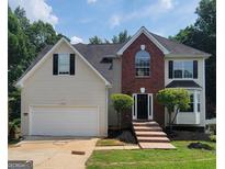 Charming two-story home boasts a manicured lawn, brick accents, and an attached two-car garage at 2587 Mead Ct, Jonesboro, GA 30236