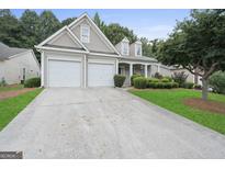 Charming home featuring a two-car garage, manicured lawn, and inviting curb appeal at 377 Avian Forest Dr, Stockbridge, GA 30281