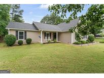 Charming single-story home with a well-manicured lawn, rocking chairs on the porch, and classic design at 200 Pine Tree Ln, Mcdonough, GA 30252