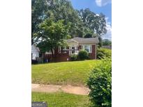 Charming brick home with front porch and a well-maintained lawn and mature trees at 978 Byron Sw Dr, Atlanta, GA 30310