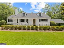 Charming home featuring a manicured lawn, black trimmed windows, and a black metal fence at 357 W Hightower Trl, Social Circle, GA 30025