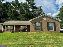 Charming brick home with a well-maintained front lawn and covered porch, inviting curb appeal and a classic design at 955 Foxworthy Ln, Riverdale, GA 30296