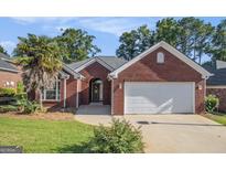 Charming brick home with a well-manicured lawn and an attached two-car garage at 286 Prominent Loop, Mcdonough, GA 30253