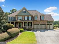 Beautiful, two-story brick home with an inviting porch and three-car garage offers fantastic curb appeal at 5585 Lavender Farms, Powder Springs, GA 30127