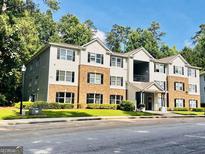 Inviting exterior view of a light-colored two-story apartment building with brick accents at 8201 Fairington Village Dr, Lithonia, GA 30034