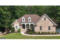 Charming brick home featuring a manicured lawn, beautiful landscaping and architectural details including dormer windows at 285 Acton Dr, Fayetteville, GA 30215