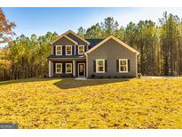 Charming two-story home with gray siding, black shutters, and a beautifully landscaped front yard at 5555 Hwy 155 N, Stockbridge, GA 30281