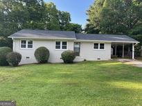 Charming single-story home with a well-maintained lawn and covered parking at 90 Pat Mell Sw Rd, Marietta, GA 30060