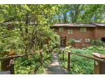 Charming brown townhouse with a stone walkway and lush landscaping at 1677 Terrell Ridge Se Dr, Marietta, GA 30067