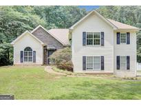 Charming two-story home with vinyl siding and a stone facade and manicured lawn at 70 N Strathmore Dr, Sharpsburg, GA 30277