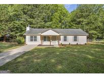 Charming single story home with a manicured lawn, brick facade, and inviting front porch at 1834 Stroud Road, Mcdonough, GA 30252
