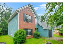 Attractive two-story home with brick and siding, dark shutters, a green lawn, and a one-car garage at 4753 Klondike Cv, Lithonia, GA 30038