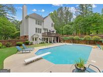 Relaxing backyard with a large pool, diving board, patio furniture, and wooded views at 495 Stonehaven Dr, Fayetteville, GA 30215