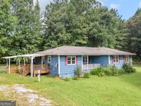 Charming single-story home featuring a covered deck, front porch, and a lush lawn at 1041 Sandy Ridge Rd, Mcdonough, GA 30252