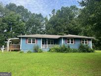 Cozy single-story home with a well-maintained lawn and mature trees in a peaceful setting at 1041 Sandy Ridge Rd, Mcdonough, GA 30252