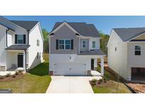 Charming two-story home with a two-car garage and manicured front lawn, perfect for suburban living at 12071 Conrad Cir, Hampton, GA 30228