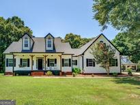 Charming white farmhouse with black accents, inviting front porch, and manicured lawn at 403 Chester Piper Rd, Covington, GA 30014